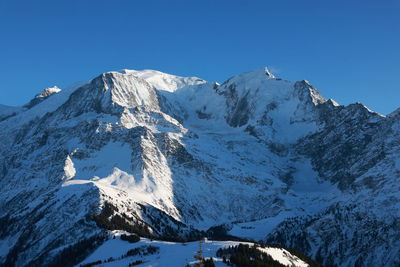 Scenic view of snowcapped mountains against clear blue sky