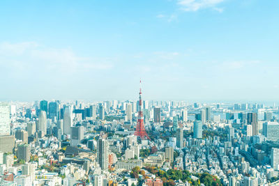 Aerial view of buildings in city against cloudy sky