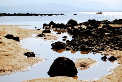 Rocks on beach against sky