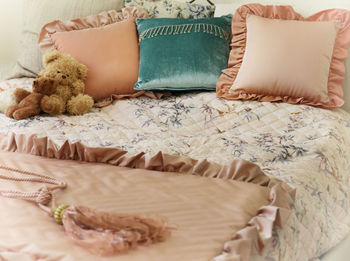 High angle view of teddy bear and pillows on bed at home