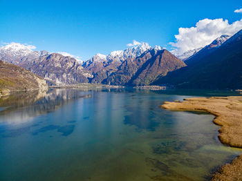 Scenic view of lake and mountains against blue sky