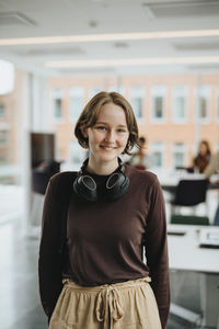 Smiling young female student standing in university