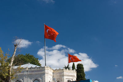 Low angle view of flag against blue sky