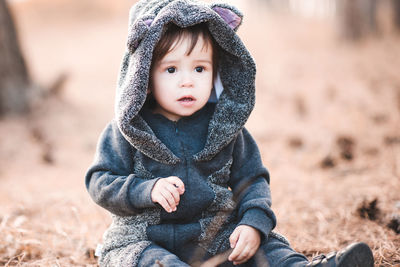 Cute boy sitting on land