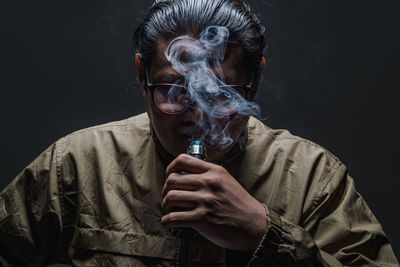 Portrait of man wearing mask against black background