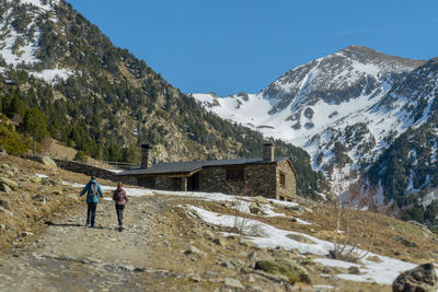 People on snowcapped mountain against sky