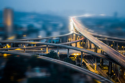 Illuminated bridge over river in city