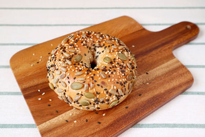 Delectable sunflower seeds and pumpkin seeds with sesame bun on wooden breadboard