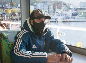 Man looking at camera while sitting on boat