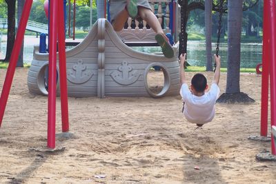 Children playing on swing in playground