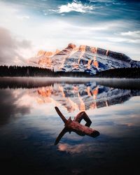 Reflection of man in lake against sky