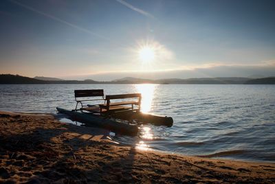 Abandoned old rusty pedal boat stuck on sand of beach. wavy water level, island on horizon. faseason