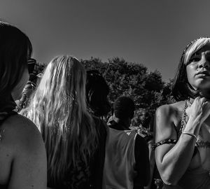 Rear view of friends standing against sky