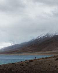 Scenic view of sea and mountains against sky
