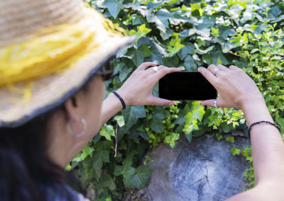 Midsection of woman photographing with mobile phone