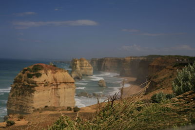 Rock formations by sea against sky