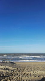 Scenic view of beach against clear blue sky