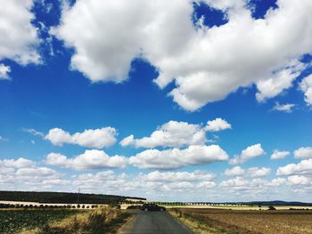 Road amidst field against sky