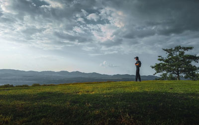 Man standing on field against sky