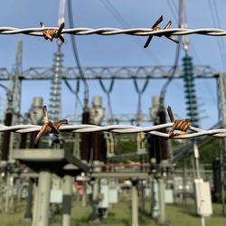 Electric plant seen through barbed wire fence