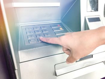 Close-up of hand touching atm keypad