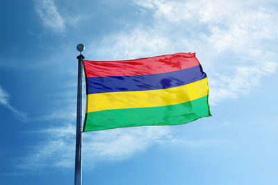 Low angle view of flag against blue sky