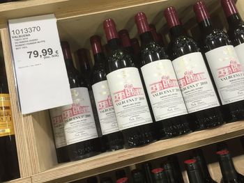 Close-up of wine bottles on shelf at store