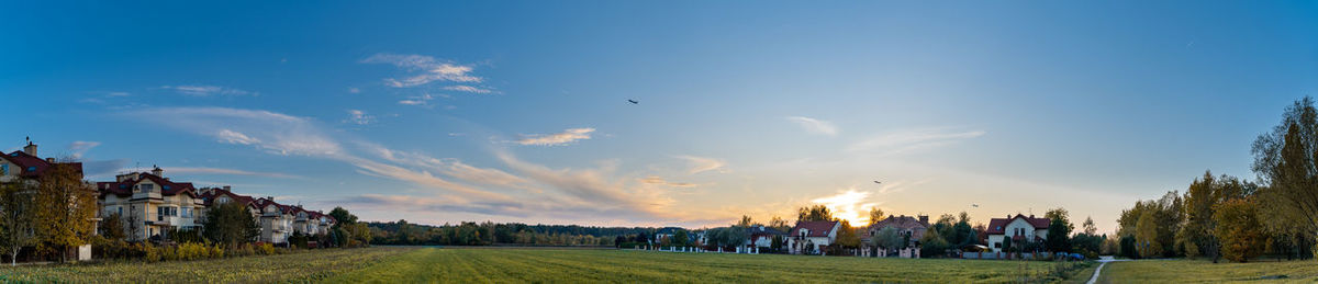 Group of people on field against sky during sunset