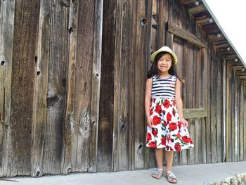 Smiling girl standing by barn