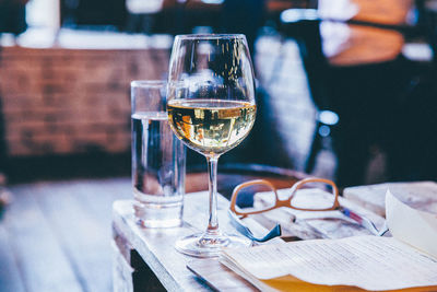 Close-up of alcohol glass next to eyeglasses