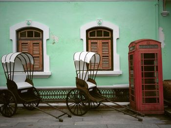 Empty chairs and tables against building