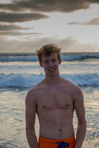 Portrait of young man standing at beach