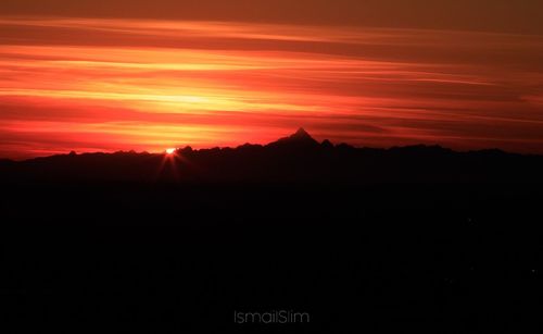 Silhouette landscape against sky at sunset