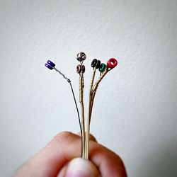 Close-up of hand holding flower over white background