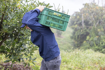 Man standing in basket on field