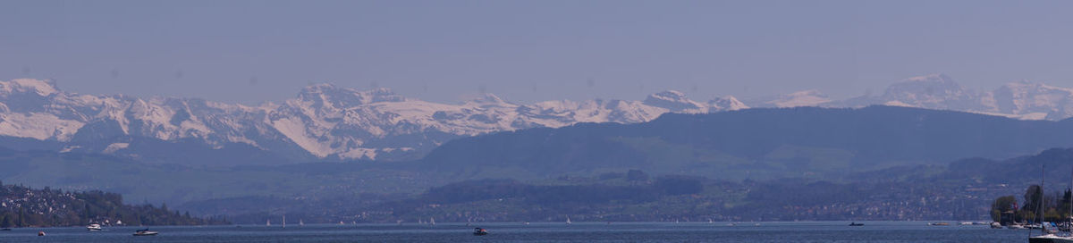 Scenic view of sea and mountains against clear sky