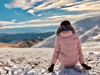 Rear view of woman looking at mountain against sky