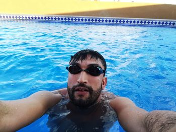 Portrait of young man swimming in pool