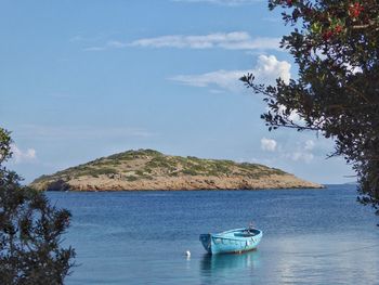 Boat in calm blue sea against mountain range