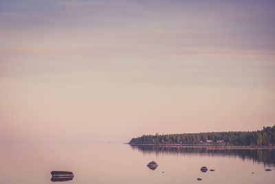 Scenic view of lake against clear sky during sunset