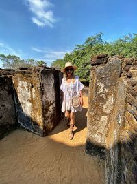 Full length of woman standing by old ruins against sky