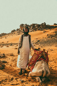 Portrait of man in desert against clear sky