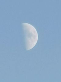 Low angle view of half moon against clear blue sky