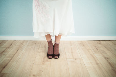 Low section of woman standing on hardwood floor