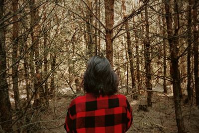 Rear view of woman standing in forest