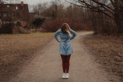 Full length of woman standing on dirt road