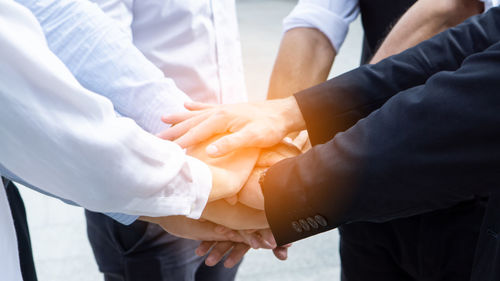 Business people stacking hands outdoors