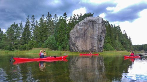 People relaxing in lake against sky