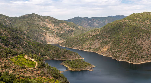 Scenic view of river amidst mountains against sky