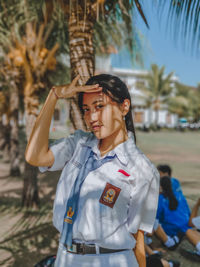 Young woman wearing sunglasses standing on field